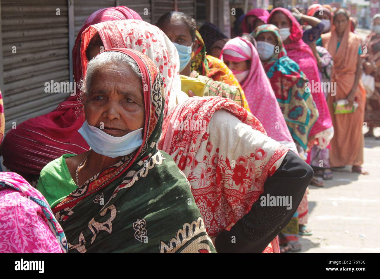 Frauen versammeln sich in einer Schlange, um Reis und Mehl vom Open Market Sale (OMS) in Modu Shohid, Sylhet, zu kaufen. Eine landesweite Sperrung wurde für 7 Tage verhängt. Bangladesch. Stockfoto