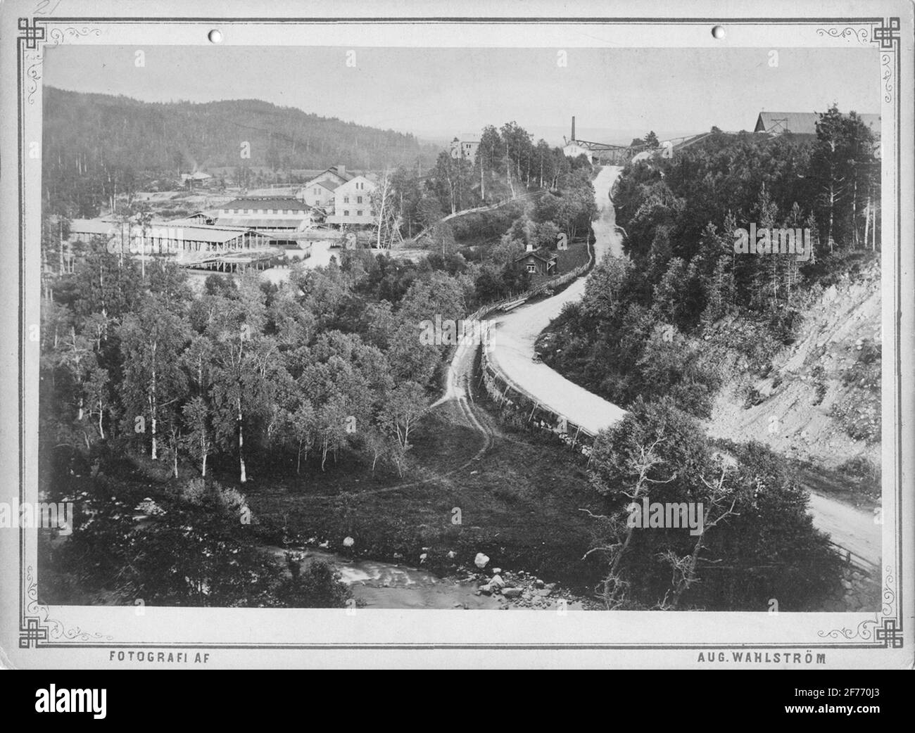 Bångbro Eisenhütte, Richtung Süden, um 1880. Im Hintergrund vom rechten Kohlenstoffhaus, der Transportweg von der Arbeit, Rostofen, Hochofengebäude. Fast der östliche Damm zur linken mechanischen Werkstatt, Blasmühle. Links von der Werkstatt Mauerwerk mit Torklada. Landsvägen Kopparberg-Löa-Ramsberg. Auf der linken Seite der Straße, die Anfang des 19. Jahrhunderts abgerissen wurde. Es war zu seiner Zeit, zur Zeit von Arboga Jororna, also vor dem Zugang der Eisenbahn zum Namen Slinkin. Stockfoto