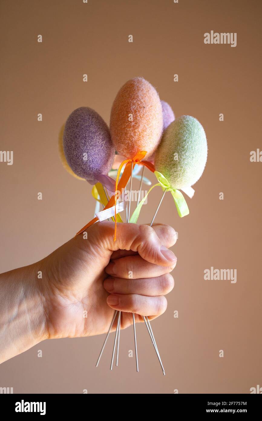 Hand hält flauschige bunte Plastikeier wie ein Strauß. Osterkonzept. Stockfoto