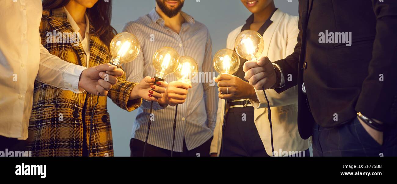 Multiethnisches Geschäftsteam, das sich als Metapher für Glühbirnen anschließt Teamarbeit und Ideenaustausch Stockfoto