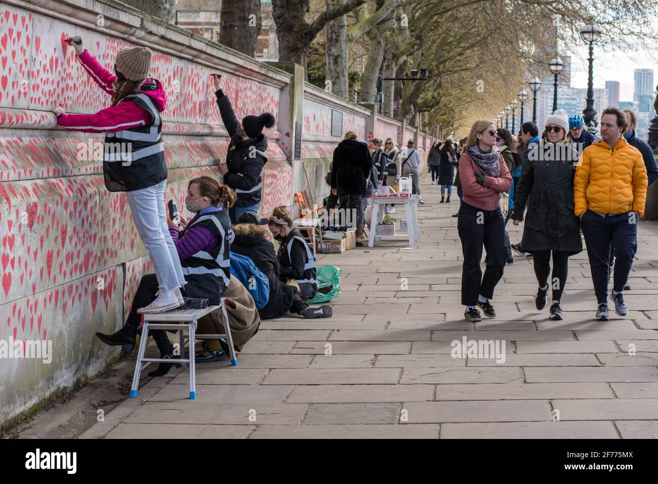 Freiwillige malen rote Herzen an der National Covid Memorial Wall in London. Die National Covid Memorial Wall in London vor dem St. Thomas' Hospital wird mit 150000 Herzen handbemalt, um die britischen Covid-19-Opfer zu ehren. (Foto von Pietro Recchia / SOPA Images/Sipa USA) Stockfoto
