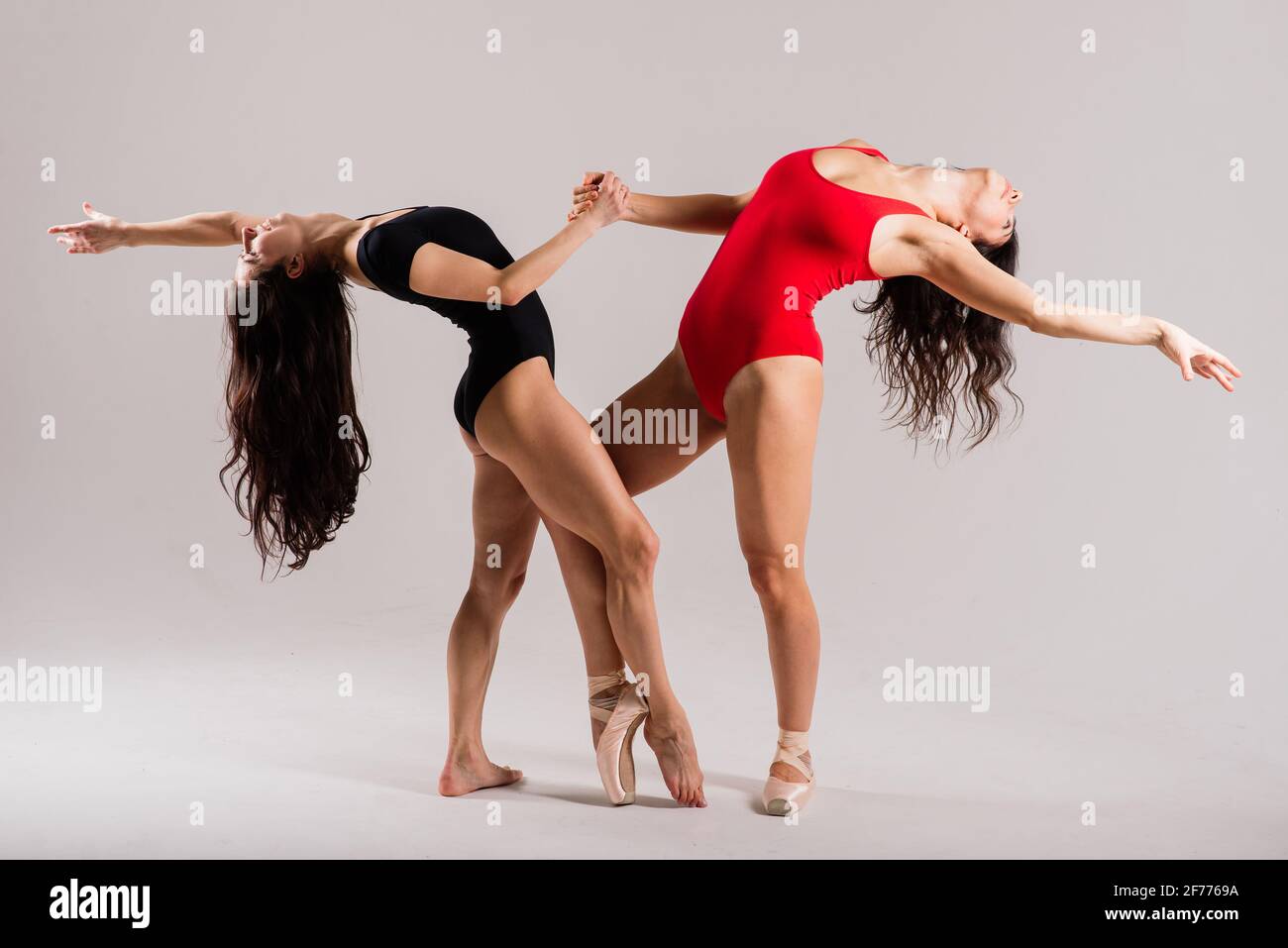 Zwei moderne Balletttänzer in schwarzem und rotem Body, Studio Stockfoto