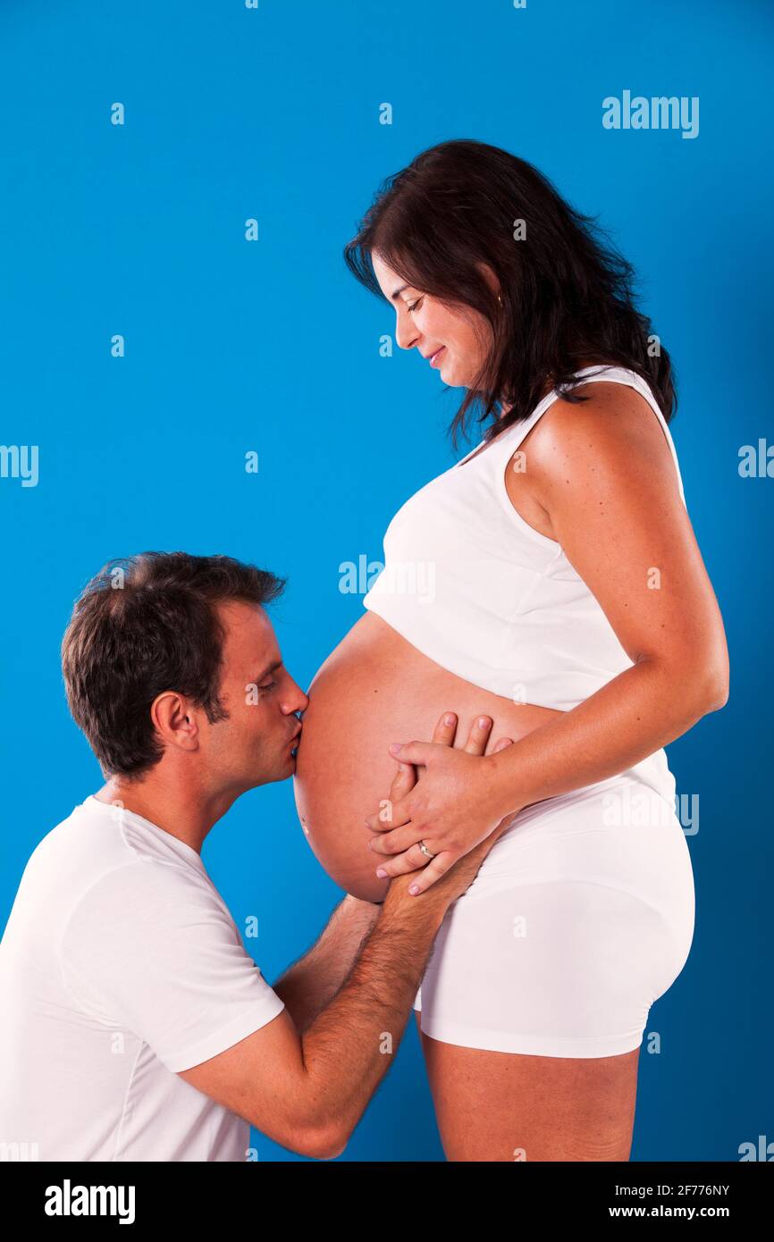 Ehemann küsst den Bauch ihrer Schwangeren Stockfoto