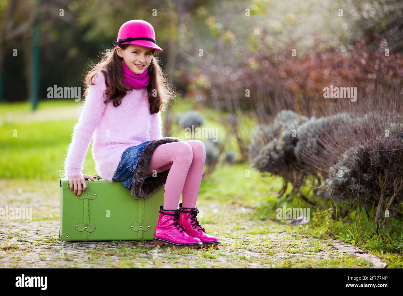 Kind bereit für die Reise sitzend auf ihre Aktentasche Stockfoto