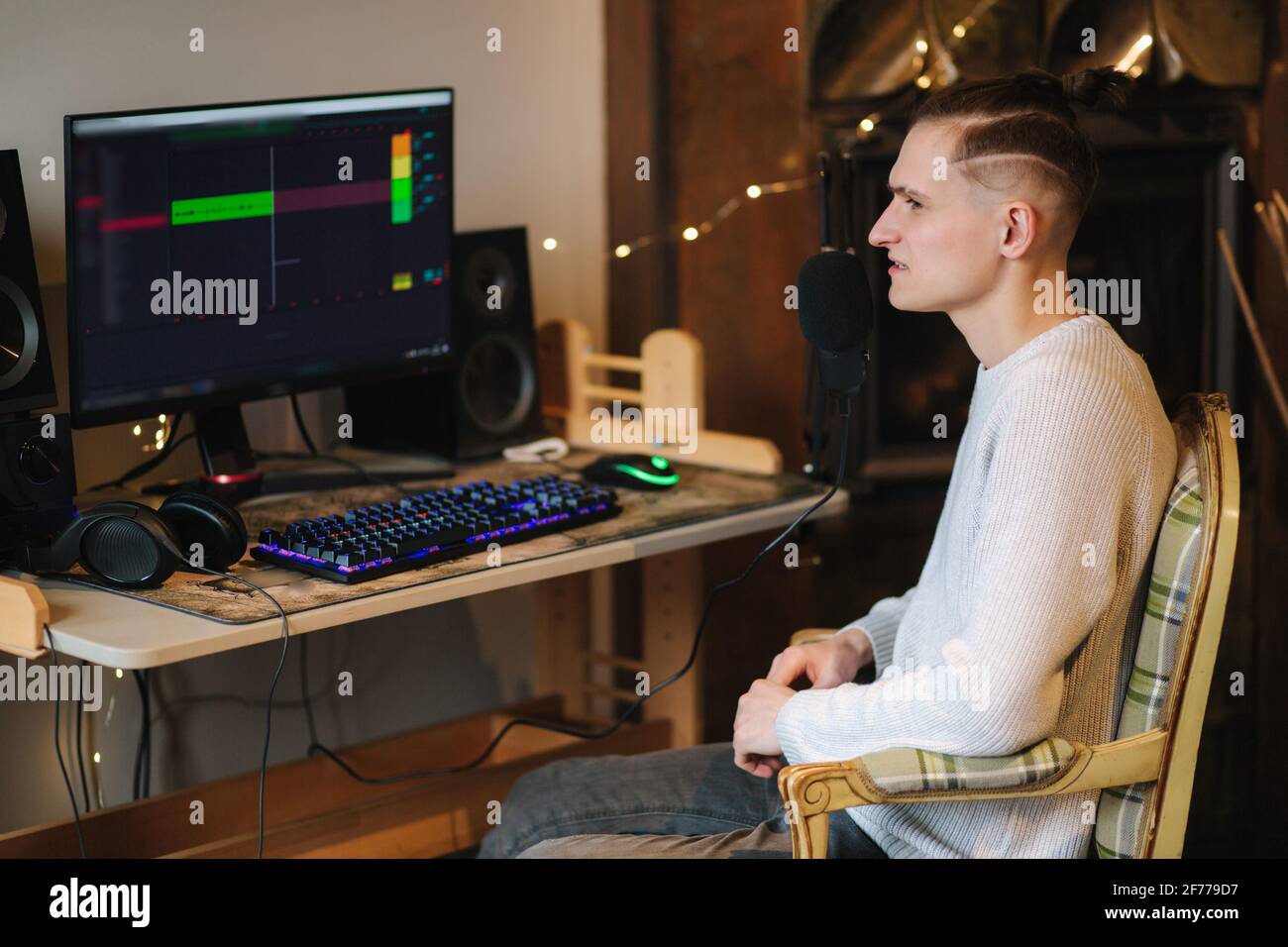 Ein junger Mann macht zu Hause einen Podcast. Mann mit pc und zwei professionellen Mikrofonen. Person, die einen Podcast zu Hause mit einem Mikrofon aufzeichnet Stockfoto