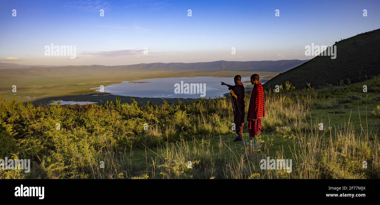 Tansania, Ngorongoro, Arusha-Region, Nationalpark, UNESCO-Weltkulturerbe, Zwei Massai-Hirten am Ende des Tages mit Blick auf den Krater des Vulkans Stockfoto