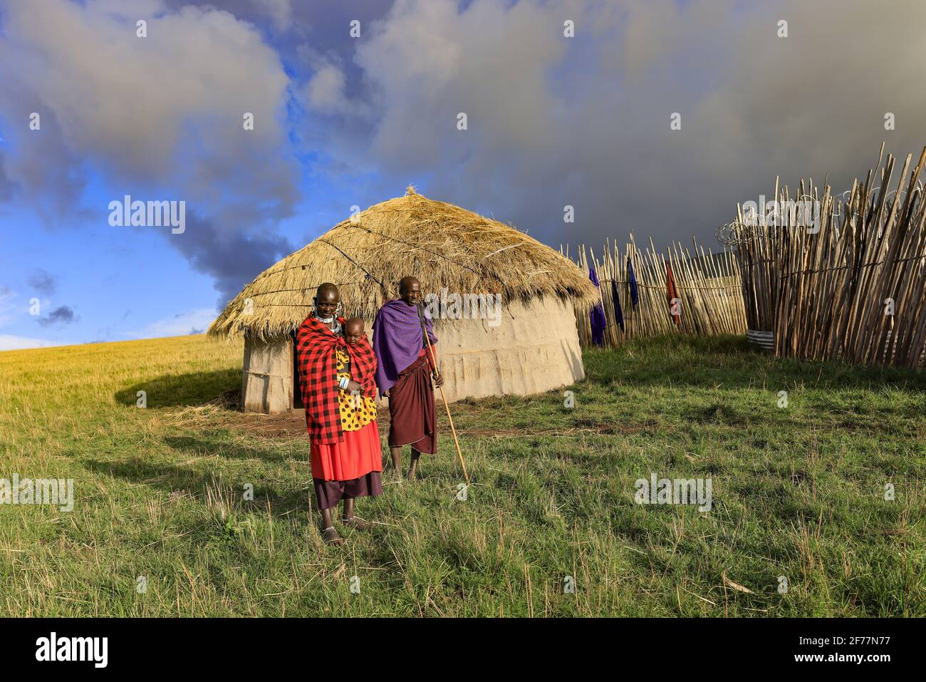 Tansania, Ngorongoro, Arusha-Region, Boma Mokila, Ngorongoro-Schutzgebiet, Ein paar Massai-Hirten mit einem Baby, am Ende des Tages im Boma Stockfoto