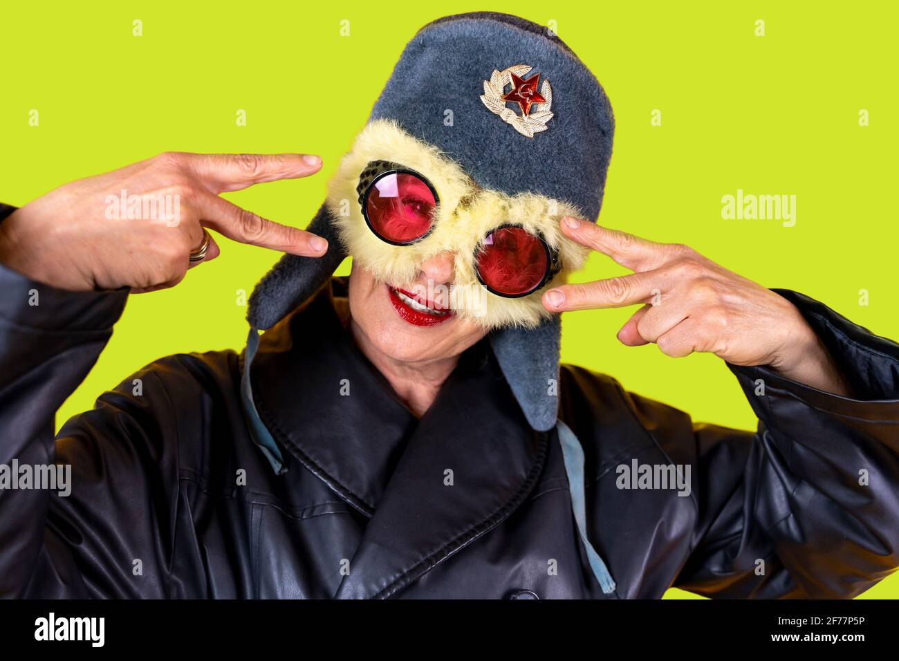 Lustige Porträt der reifen Frau. Lady posiert als russische Fliegerin. Reife Frau auf farbigen Hintergründen Stockfoto