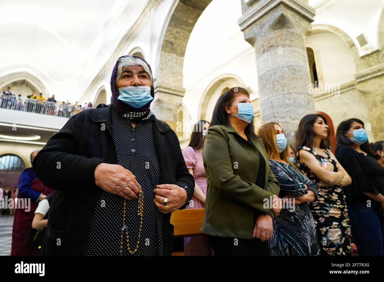 Mosul, Ninive, Irak. April 2021. Irakische Christen nehmen an der Ostermesse in der Großen Unbefleckten Kirche (al-Tahira-l-Kubra) in der Stadt Qaraqosh (Al-Hamdaniya), 30 Kilometer südöstlich der Stadt Mosul, Teil. Ostern gilt als größter und größter christlicher Feiertag, Es erinnert an die Auferstehung Christi von den Toten nach drei Tagen seiner Kreuzigung und seines Todes, wie im Neuen Testament geschrieben, in dem die große Fastenzeit, die gewöhnlich vierzig Tage dauert, endet. Während der Liturgie werden die Hymnen gesungen, Teile des Alten Testaments aus der Bibel rezitiert, die Hymnen des Hallelujah ar Stockfoto