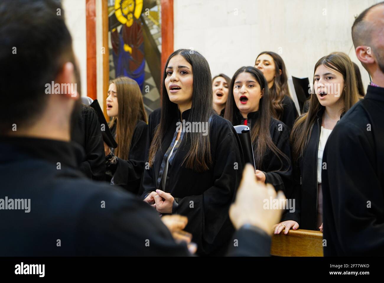 Mosul, Ninive, Irak. April 2021. Mitglieder des Kirchenchors singen während der Ostermesse in der Großen Unbefleckten Kirche (al-Tahira-l-Kubra) in der Stadt Qaraqosh (Al-Hamdaniya), 30 Kilometer südöstlich der Stadt Mosul.Ostern gilt als der größte und größte christliche Feiertag, Es erinnert an die Auferstehung Christi von den Toten nach drei Tagen seiner Kreuzigung und seines Todes, wie im Neuen Testament geschrieben, in dem die große Fastenzeit, die gewöhnlich vierzig Tage dauert, endet. Während der Liturgie werden die Hymnen gesungen, Teile des Alten Testaments aus der Bibel rezitiert, Th Stockfoto