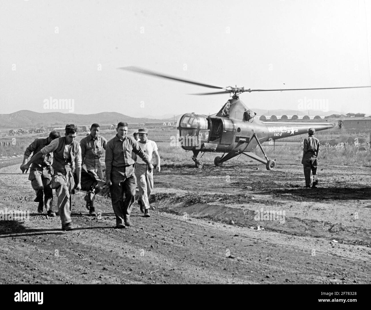 Evakuierung Des Koreanischen Kriegsverfalles. Die Korpsmänner der Marine Herald B. Williams, James E. Carr und William N. Shipworth tragen einen verwundeten Mann aus einem Evakuierungshubschrauber des US Marine Corps HO3S-1 in ein Krankenhaus in Korea. Der Hubschrauber stammt von der Staffel VMO-6. Das Originalfoto datiert vom 3. Oktober 1950, in diesem Fall wurde es wahrscheinlich während der Operationen des Marine Corps in der Nähe von Seoul, Korea, aufgenommen. Stockfoto