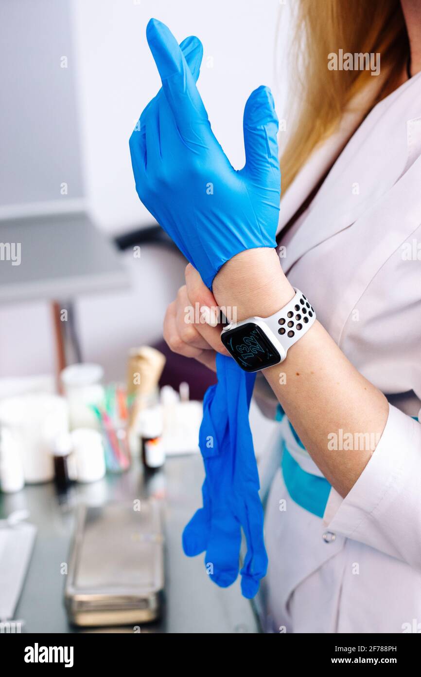 Ärztin legt einen medizinischen Handschuh auf ihre Hand Stockfoto