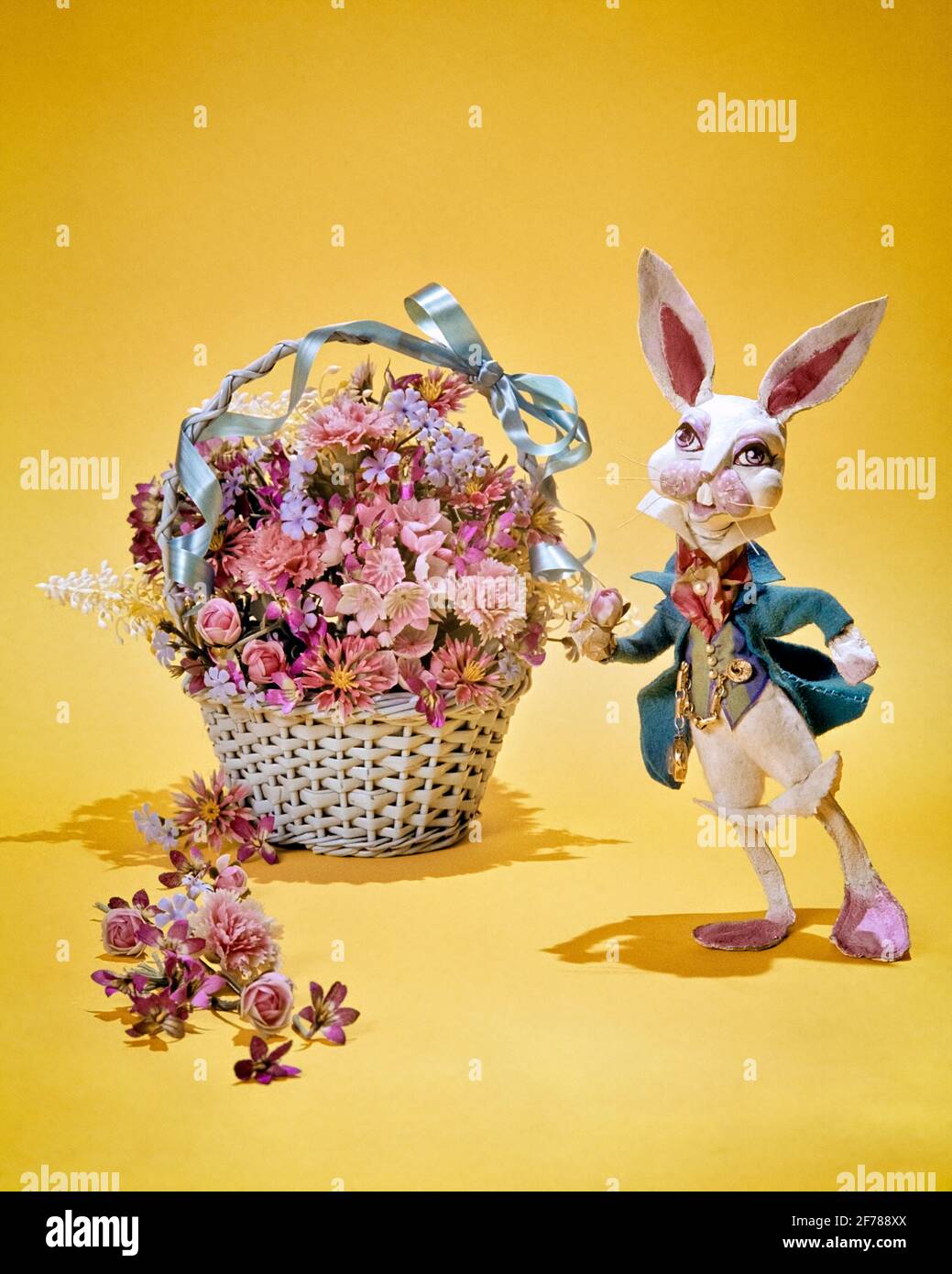 70ER JAHRE EIN KANINCHEN IN EINEM KOSTÜM NEBEN EINEM KORB MIT ROSA BLÜHT DER OSTERHASE ODER DER MÄRZHARE AN GELB NAHTLOS - KE1049 PHT001 HARS ODER LITERARISCHER MARSCHHARE PETER KANINCHEN ALTMODISCH Stockfoto