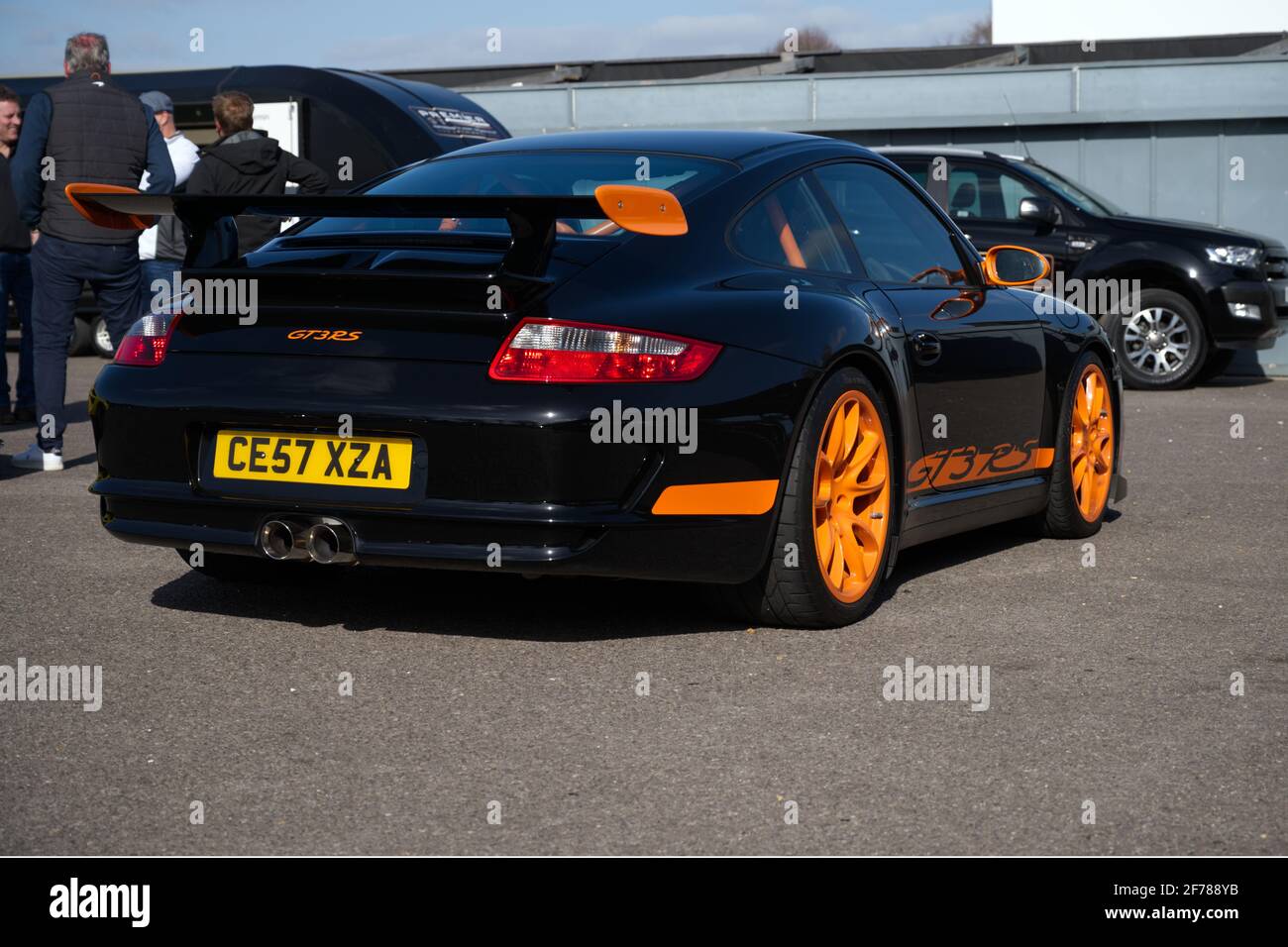 Ein Porsche GT3 RS Supersportwagen in Schwarz mit orangefarbener Verkleidung bei einem Track Day Meeting. Stockfoto