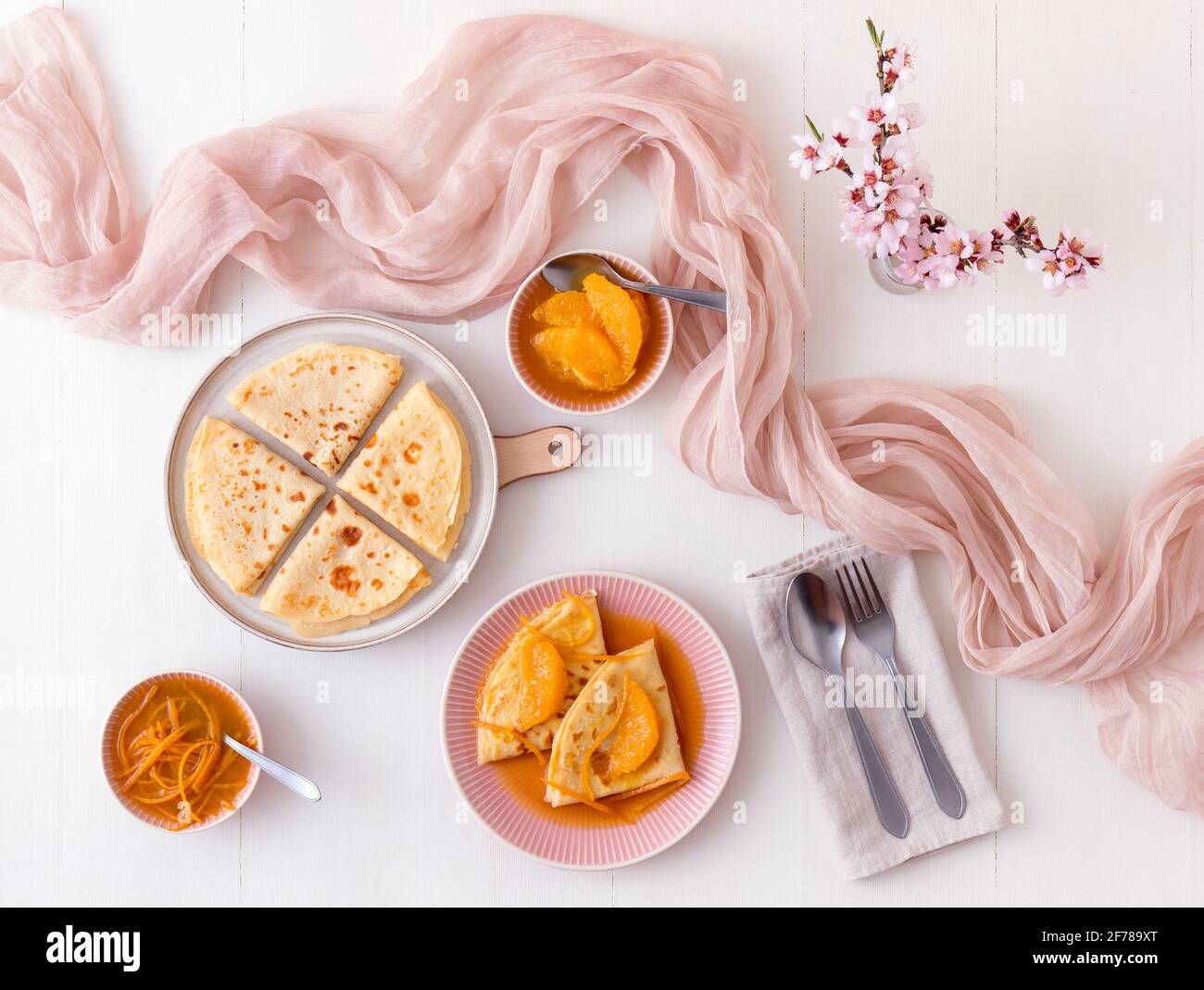 Pancakes Suzette, traditionelles französisches Dessert. Pfannkuchen mit Orangen. Weißer Holztisch. Draufsicht. Stockfoto