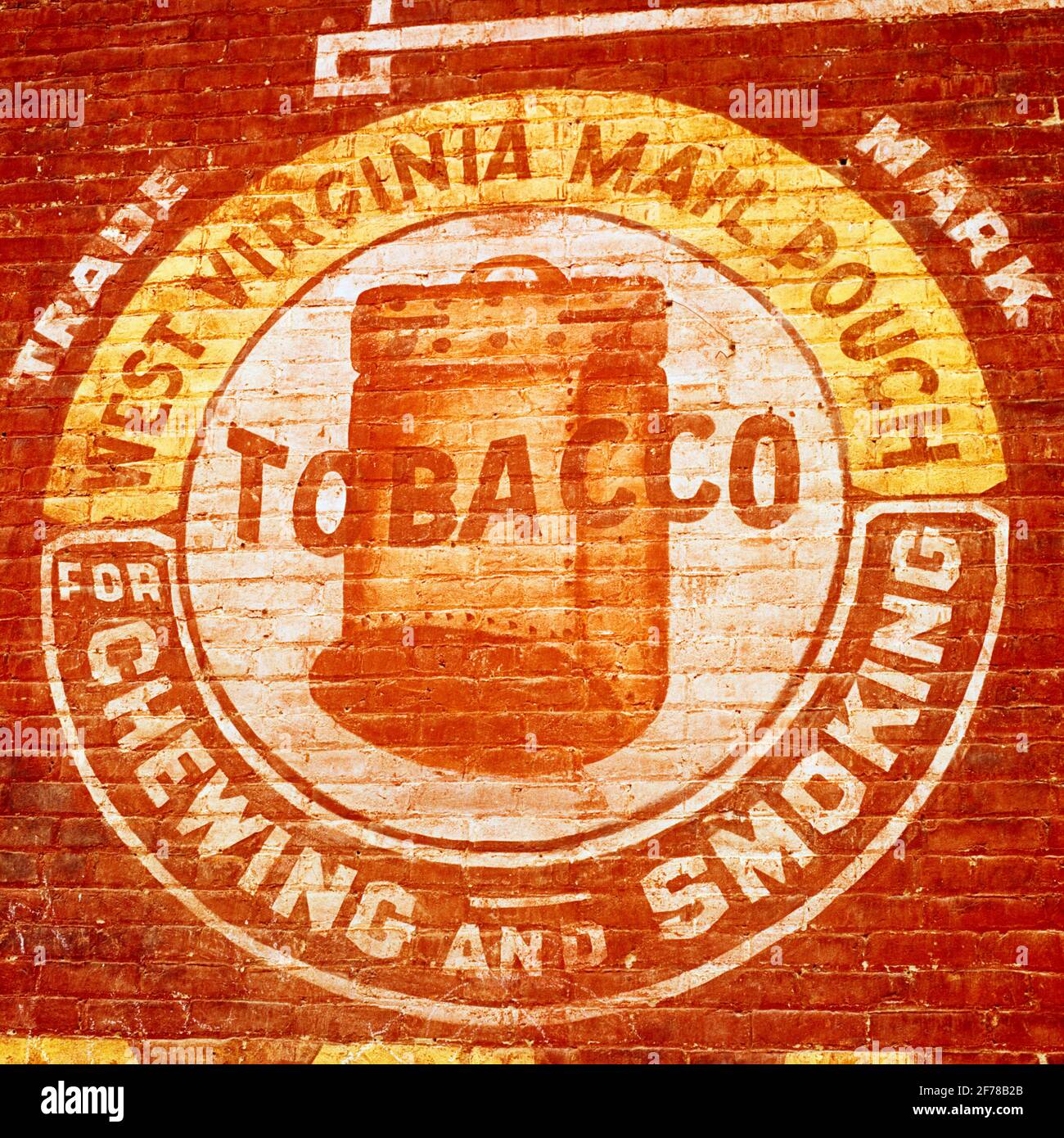 EIN VERBLASSENES SCHILD AUS DEN 1970ER JAHREN AN DER AUSSENWAND DES ZIEGELGEBÄUDES ORIGINAL WEST VIRGINIA POSTBEUTEL TABAK JACKSON COUNTY ODER USA - KS9940 LAM001 HARS ALTMODISCH Stockfoto