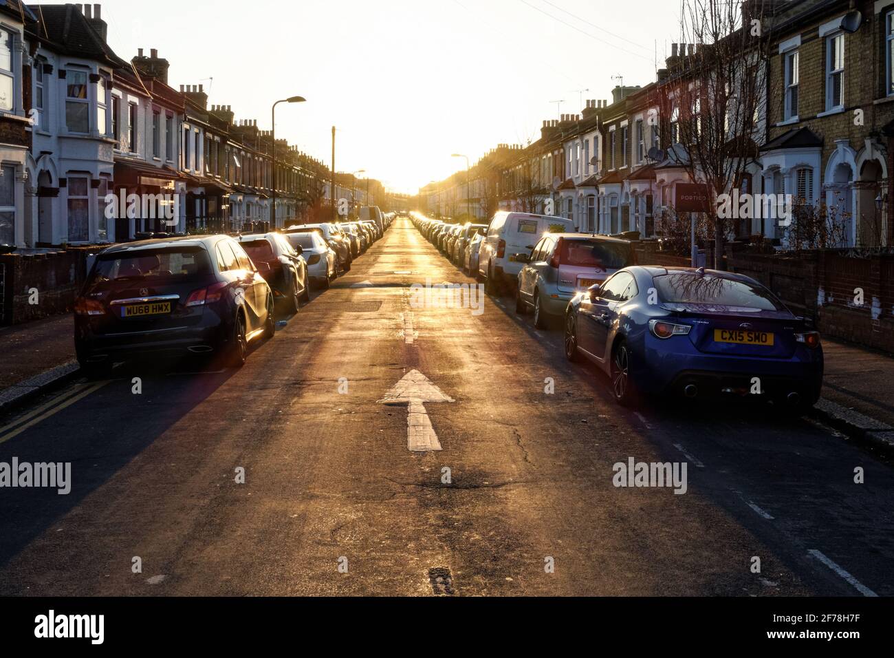 Reihenhäuser auf beiden Seiten der Wohnstraße in London bei Sonnenuntergang, England Vereinigtes Königreich Großbritannien Stockfoto