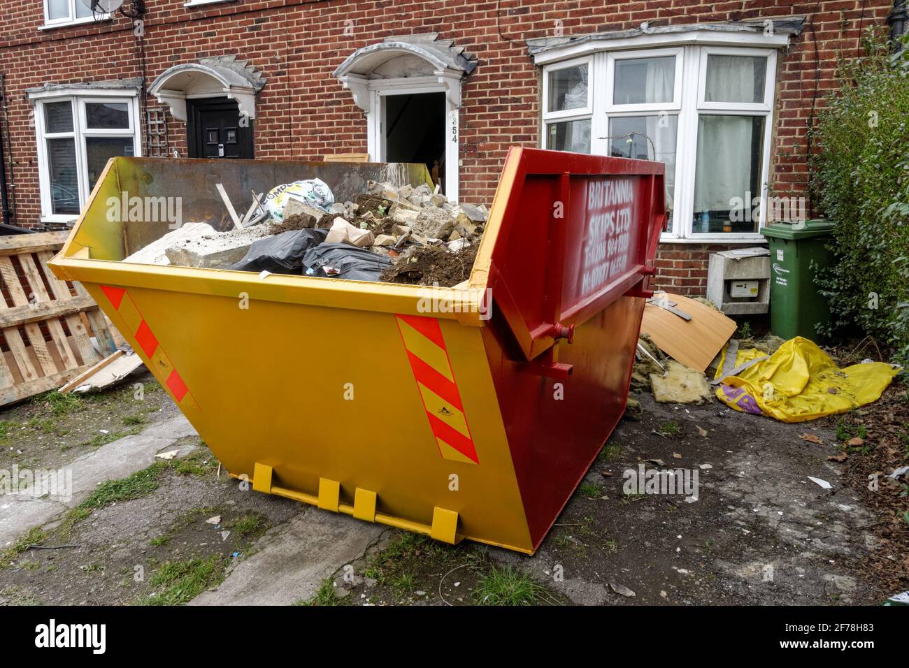 Skip bin Abfallcontainer vor einem Haus in East London, England Großbritannien Stockfoto