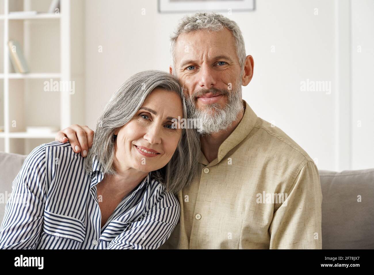 Glückliches, reifes Paar im mittleren Alter, umarmt sich und verklebt zu Hause. Nahaufnahme im Hochformat. Stockfoto