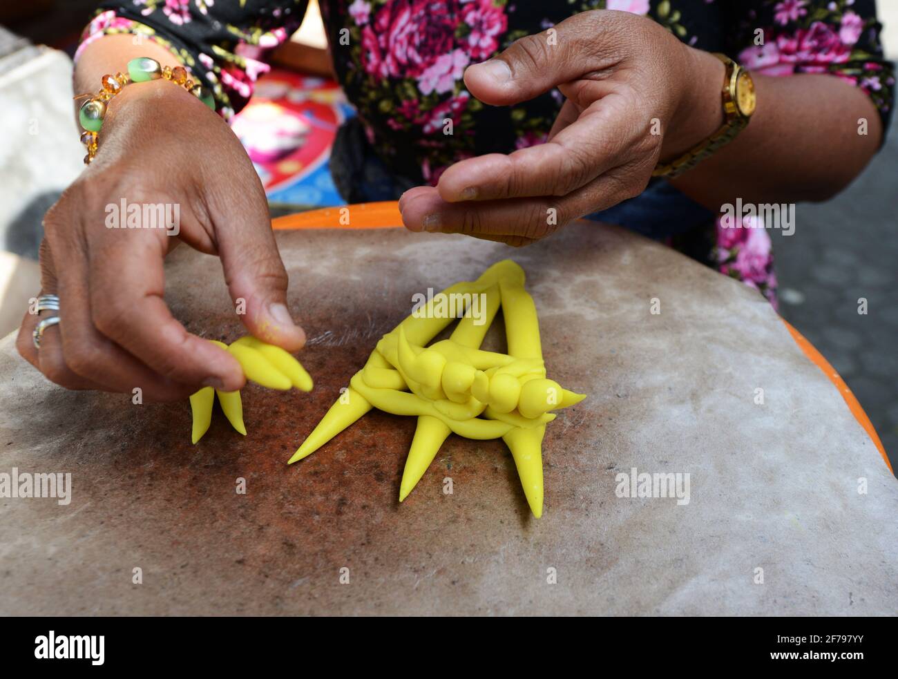 Balinesin bereitet eine handgemachte Opfergabe namens Jajan Suci oder Palegembai in einem Hindu-Tempel in Bali, Indonesien, vor. Stockfoto