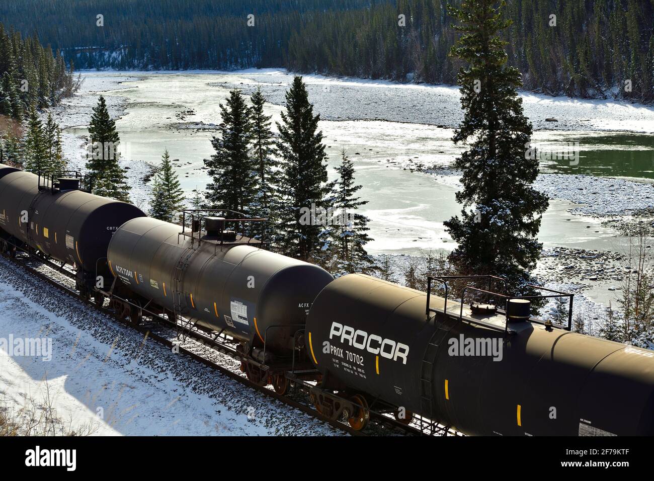 Ein kanadischer nationaler Güterzug, der mit Öltankwagen beladen ist Reisen entlang des Athabasca Flusses in einem bewaldeten Gebiet von Die felsigen Berge in Alberta können Stockfoto