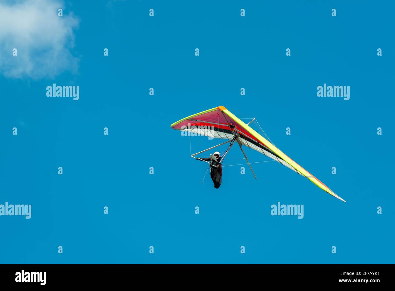Fliegende Pilotin. Farbenprächtiger Drachenflügel, der unter der Wolke schwebt Stockfoto