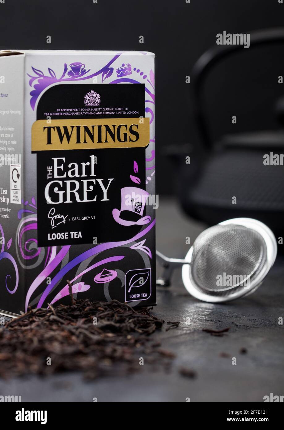 LONDON, Großbritannien - 21. OKTOBER 2020: Box mit Twinings Earl Grey loser Tee mit eiserner Teekannen und Sieb-Infuser auf schwarzem Hintergrund. Stockfoto