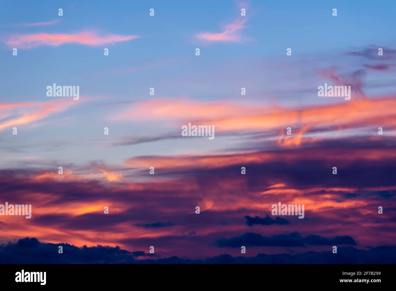 Ein bunter Himmel bei Sonnenuntergang mit Wolken in vielen gemalt Schattierungen von rosa bis schwarz Stockfoto