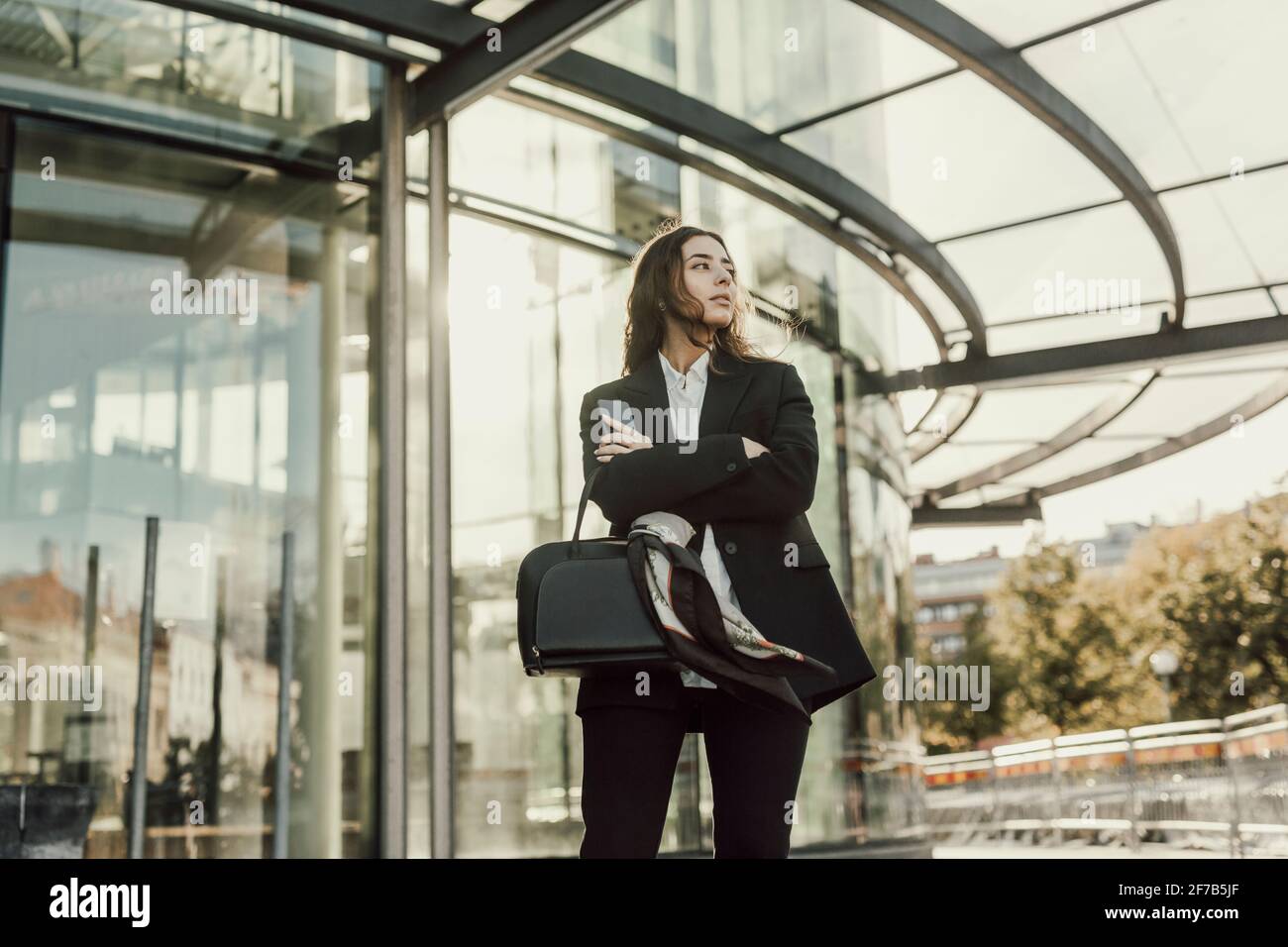 Geschäftsfrau, die vor dem Bürogebäude steht Stockfoto