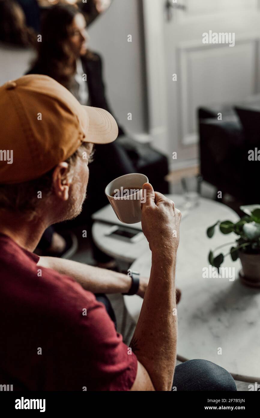 Mann, der während eines Bürotreffens Kaffee getrunken hat Stockfoto