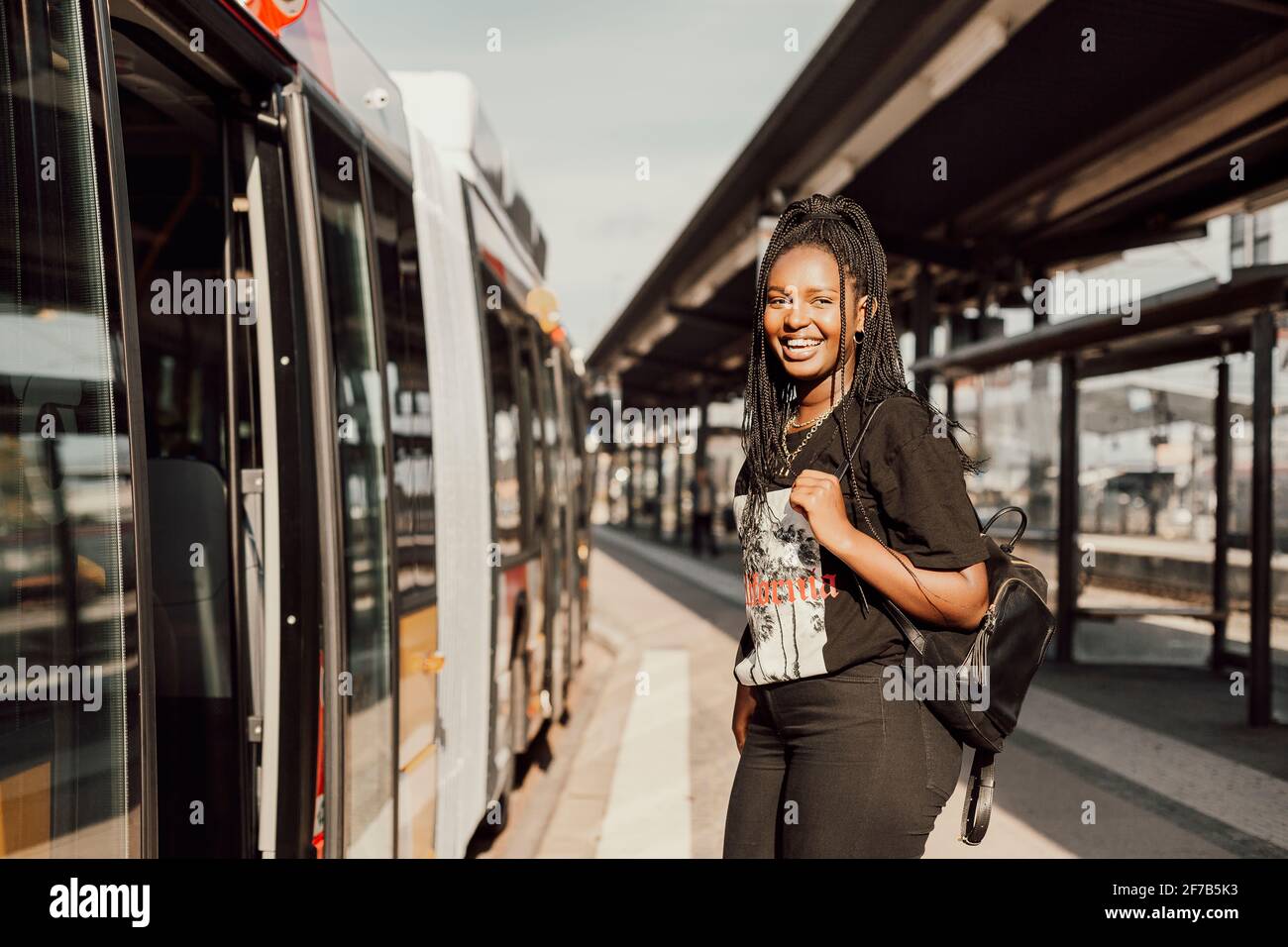 Junge Frau warten am Busbahnhof Stockfoto