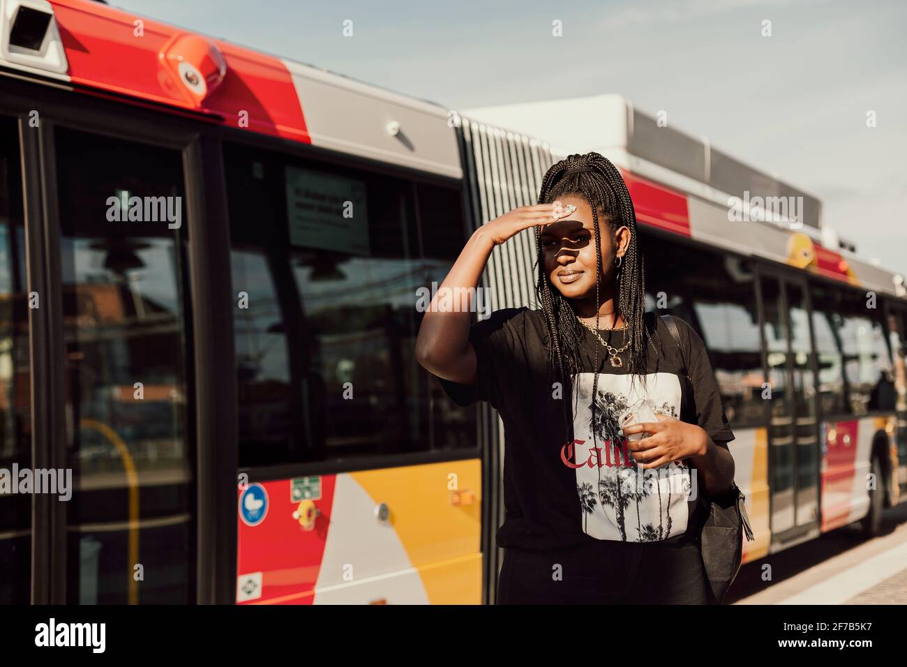 Junge Frau warten am Busbahnhof Stockfoto