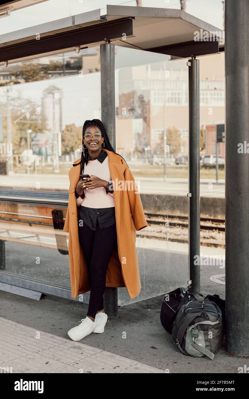 Junge Frau warten am Busbahnhof Stockfoto