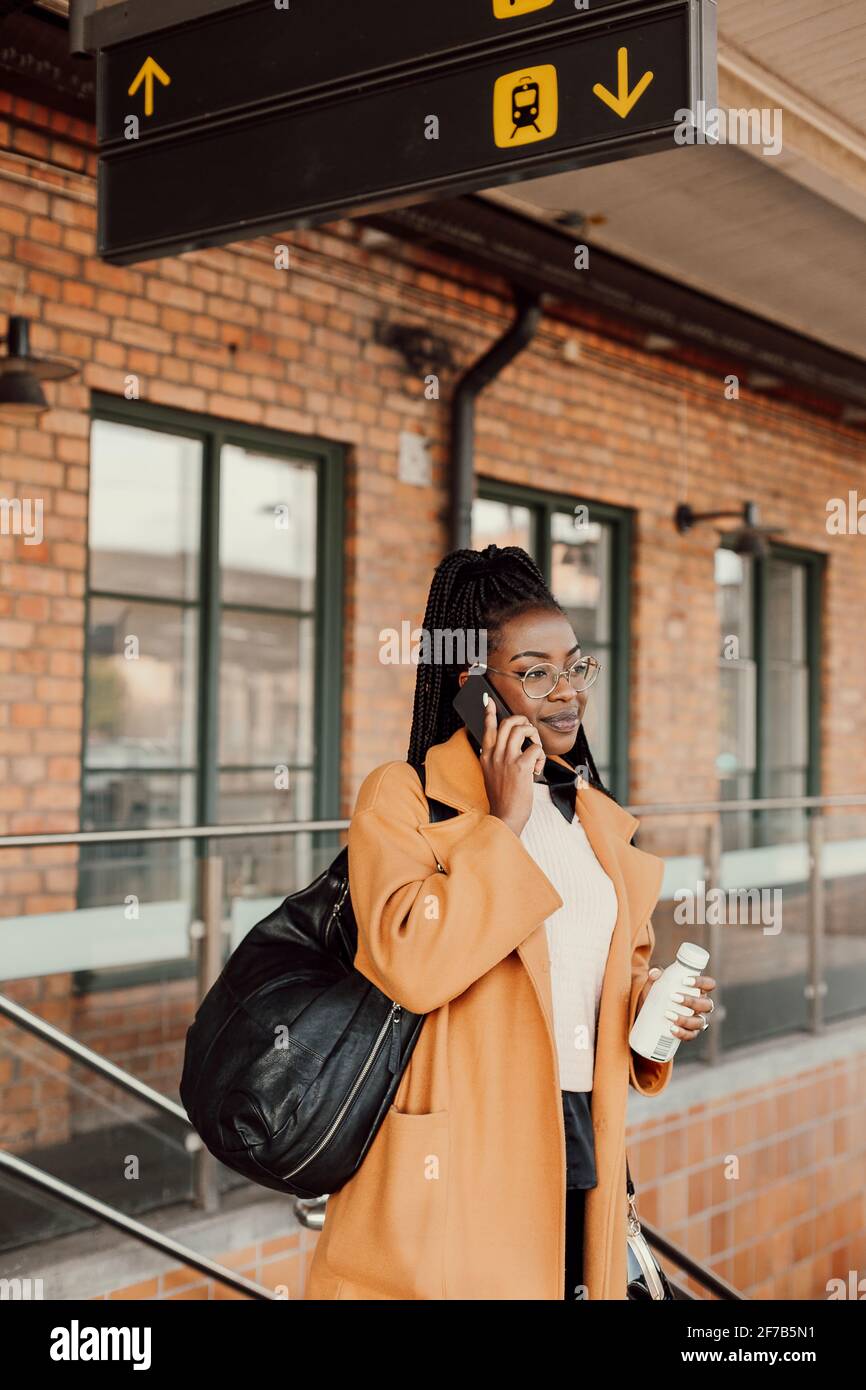 Junge Frau warten am Busbahnhof Stockfoto