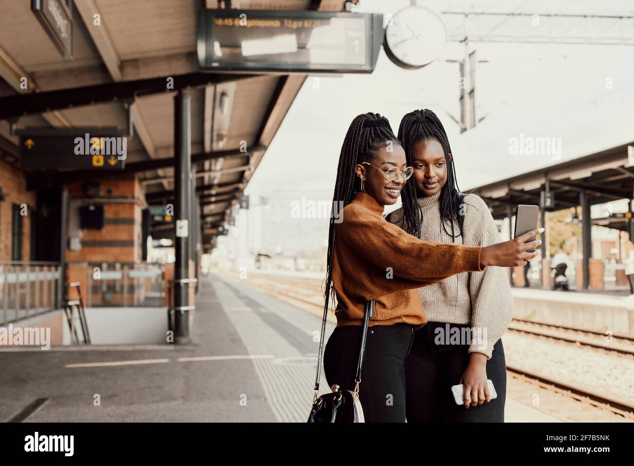 Lächelnde Frauen, die am Bahnhofsplatz Selfie machen Stockfoto