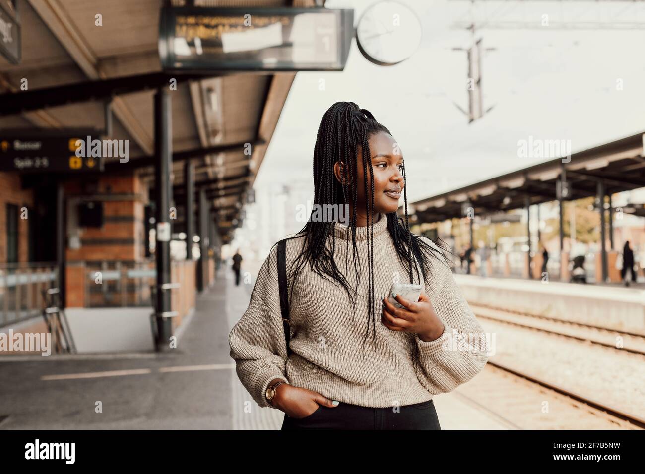 Junge Frau am Bahnhof warten Stockfoto