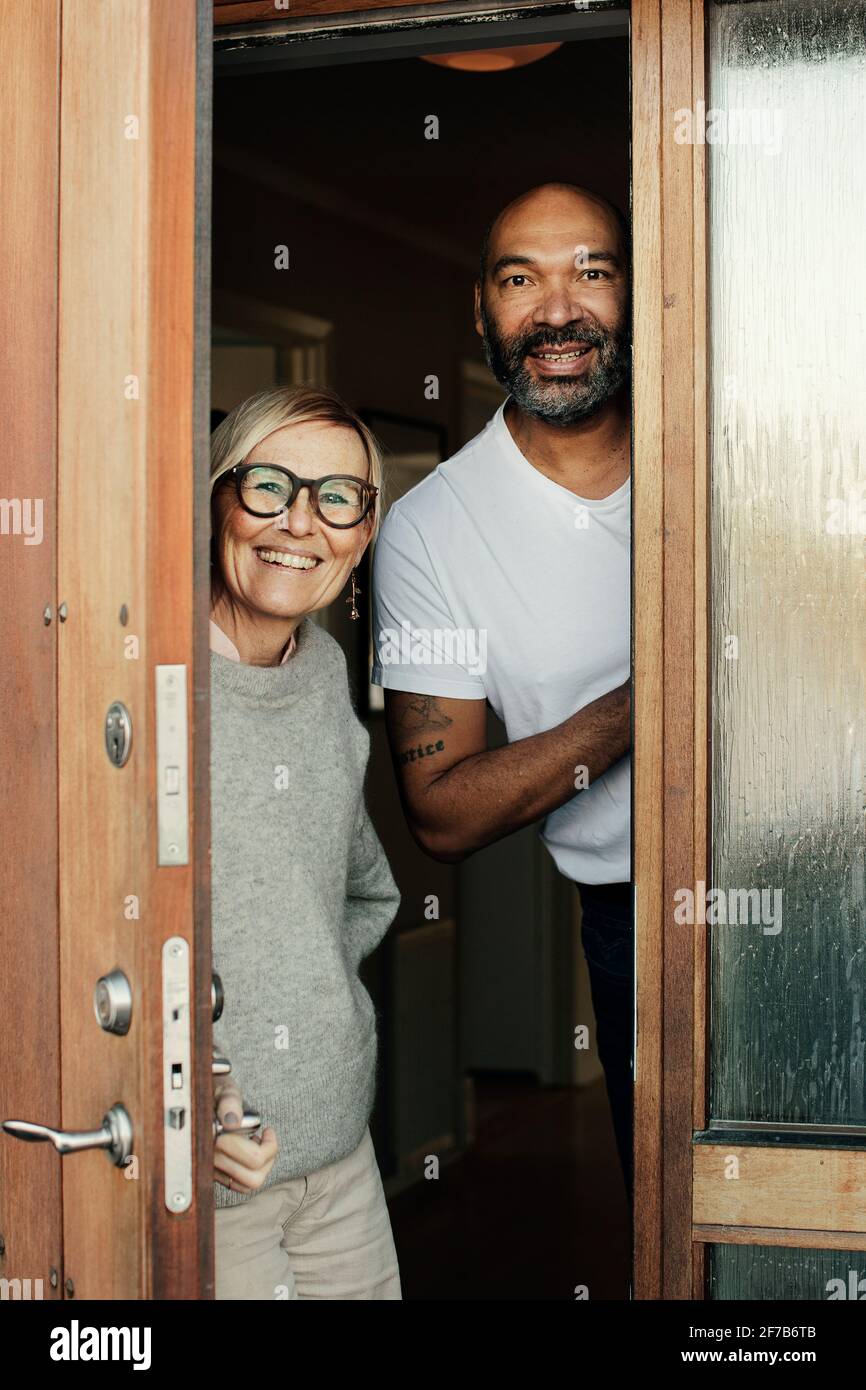 Lächelndes reifes Paar vor der Tür Stockfoto