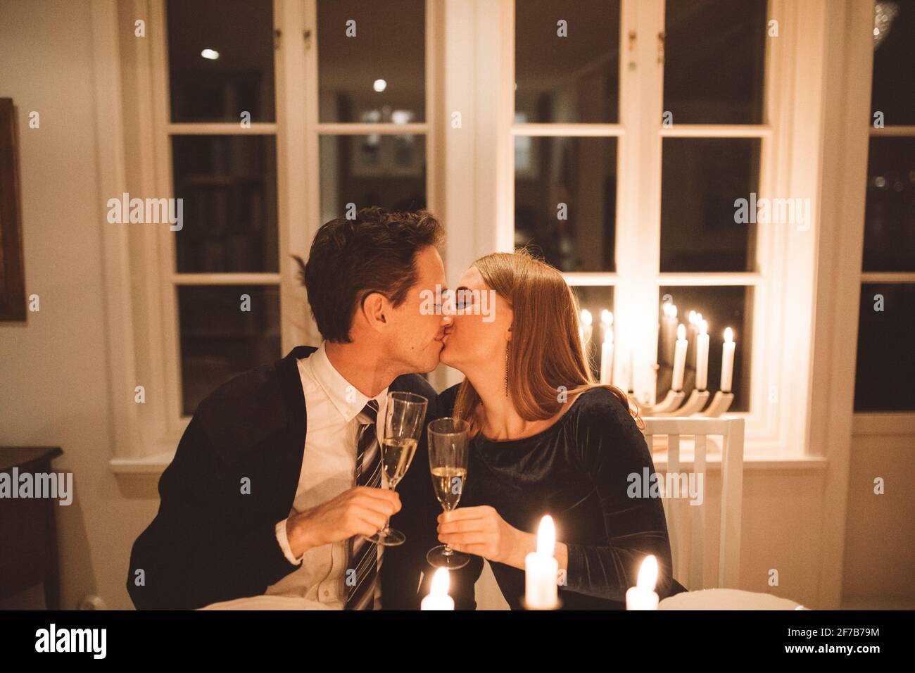 Küssendes Paar mit Sektflöten Stockfoto