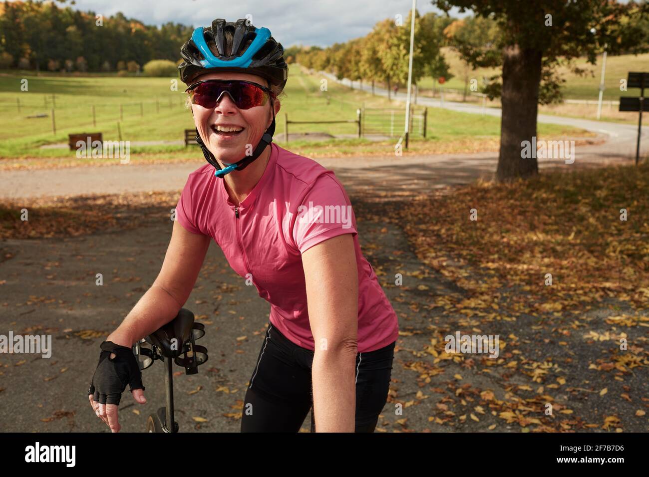 Glückliche Radfahrerin beim Betrachen der Kamera Stockfoto