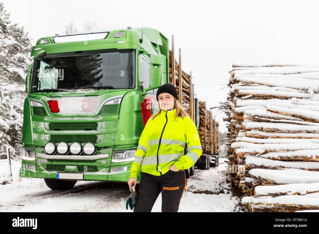 Lächelnde Frau, die vor einem Lastwagen steht Stockfoto