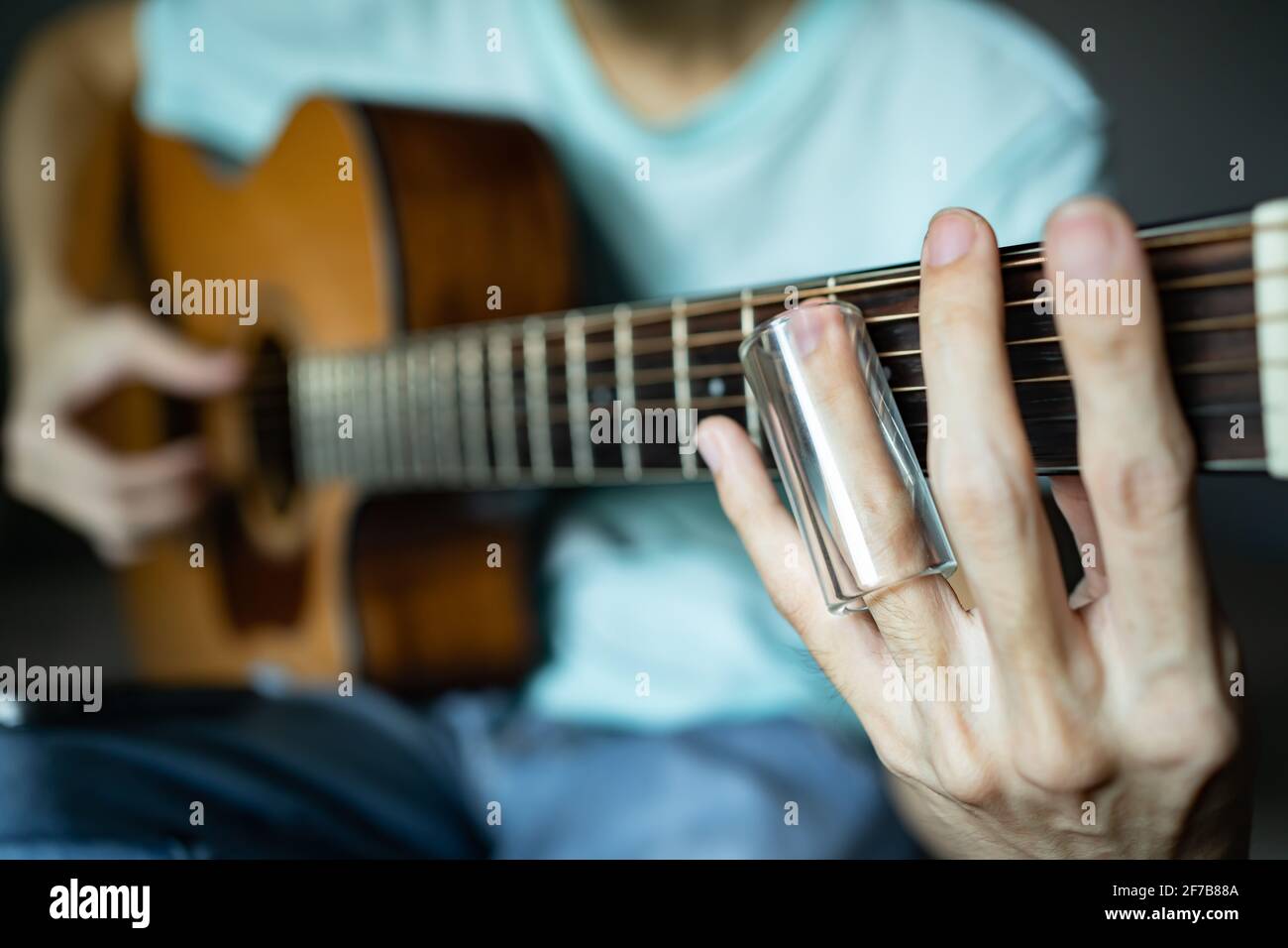 Gitarre spielen mit Glasrutsche Stockfoto