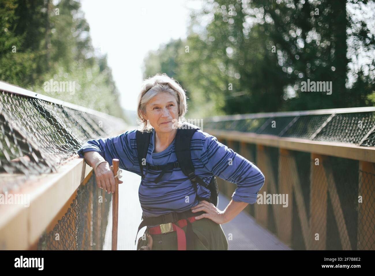 Ältere Frau, die auf einer Fußgängerbrücke steht Stockfoto