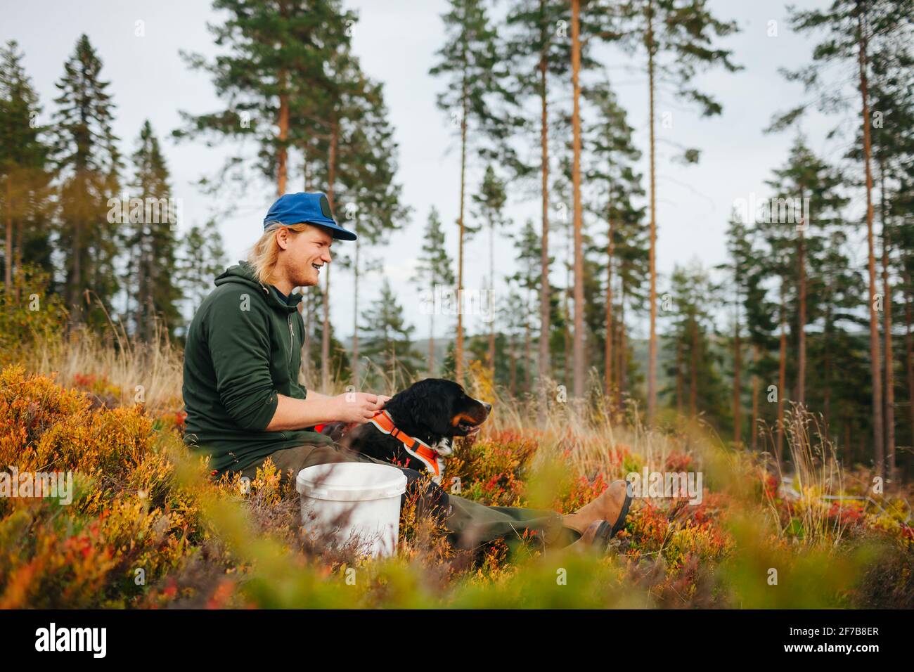 Lächelnder Mann mit Hund, der wegschaut Stockfoto