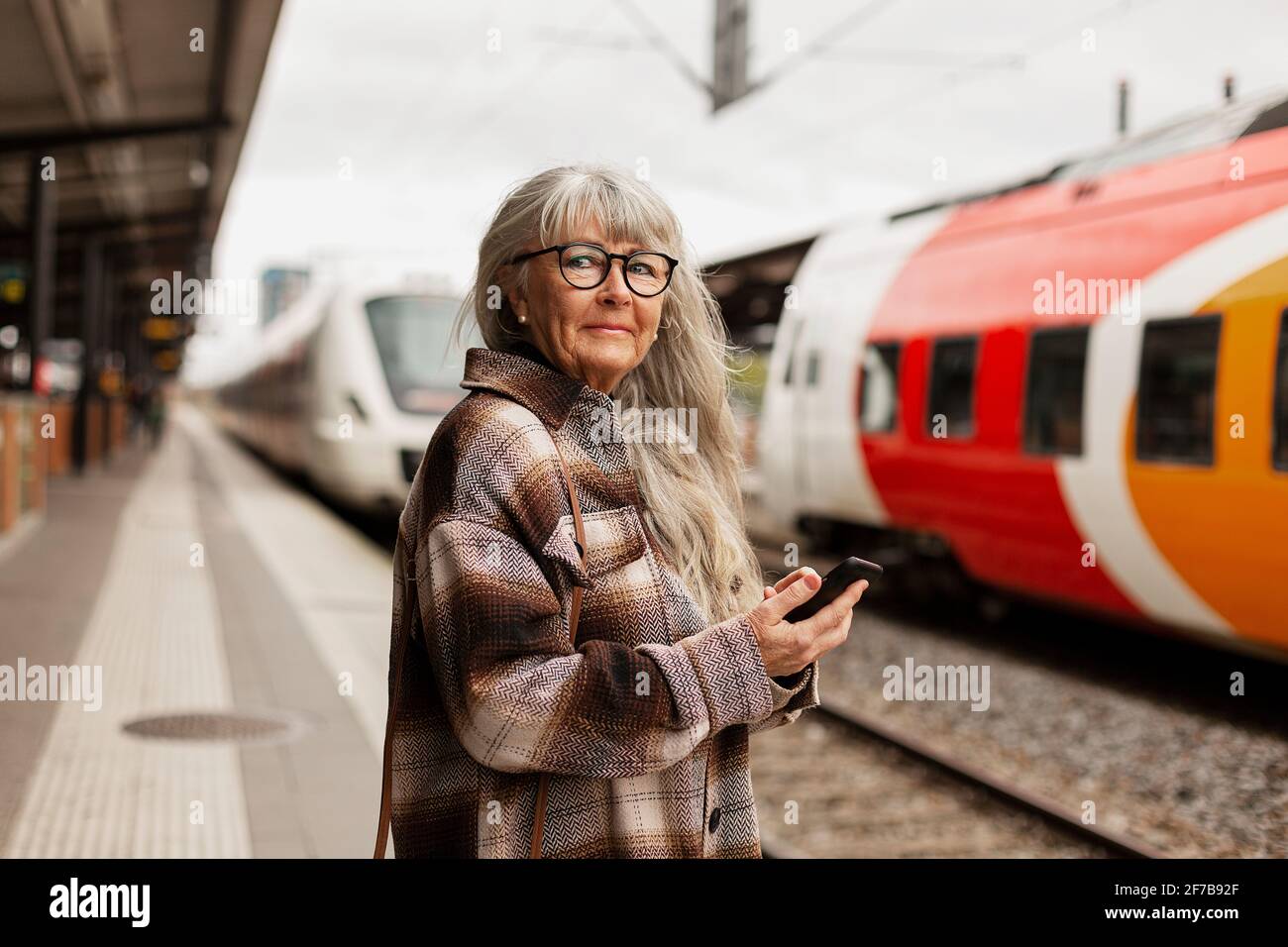 Reife Frau am Bahnhof Stockfoto