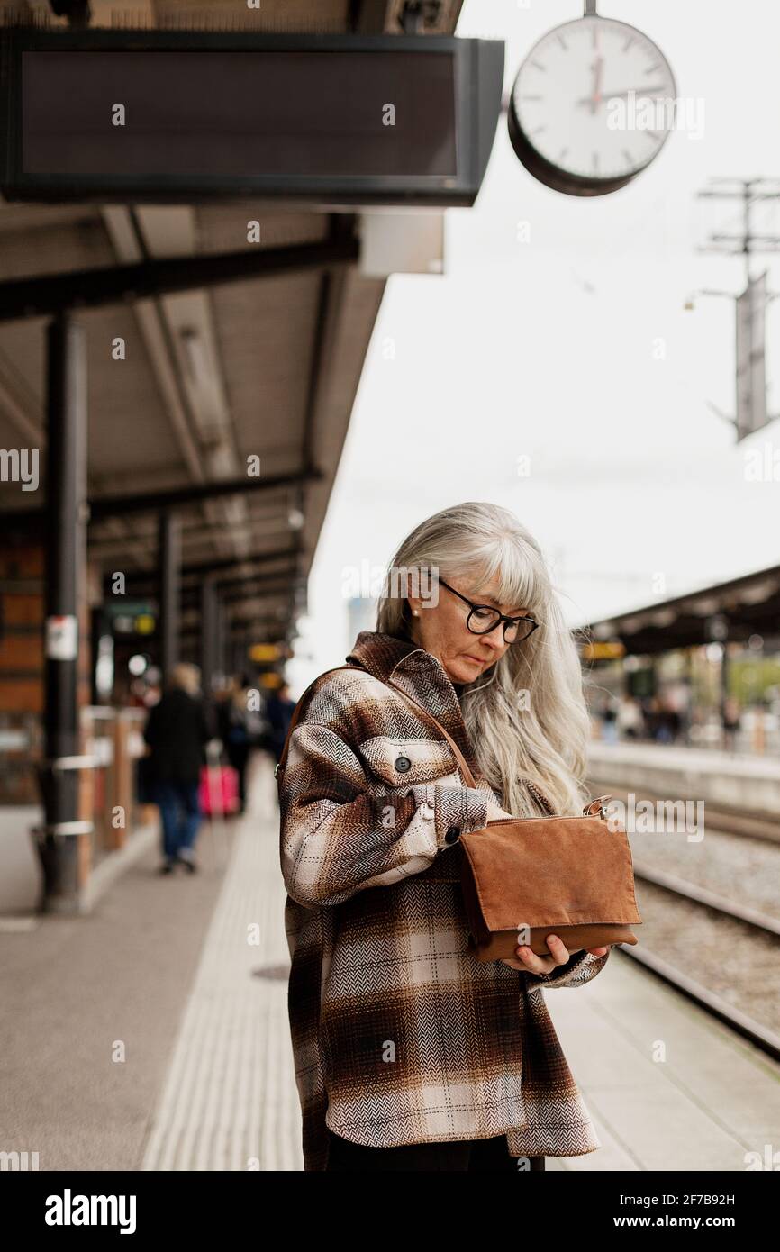 Reife Frau am Bahnhof Stockfoto