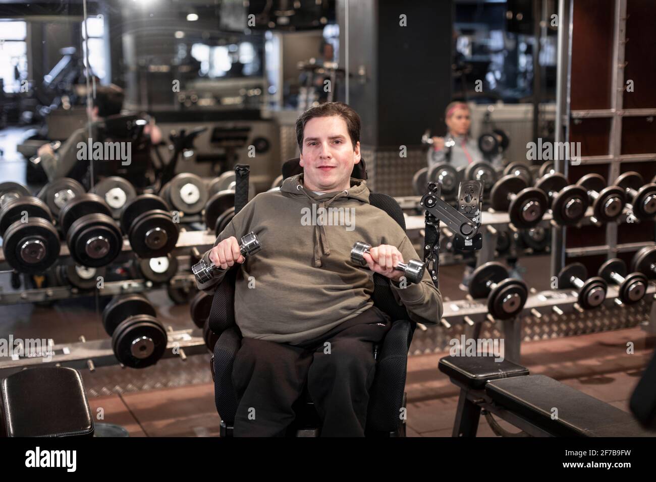 Mann im Rollstuhl trainiert im Fitnessstudio Stockfoto