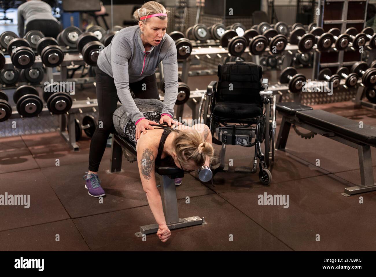 Frau trainiert im Fitnessstudio mit Personal Trainer Stockfoto