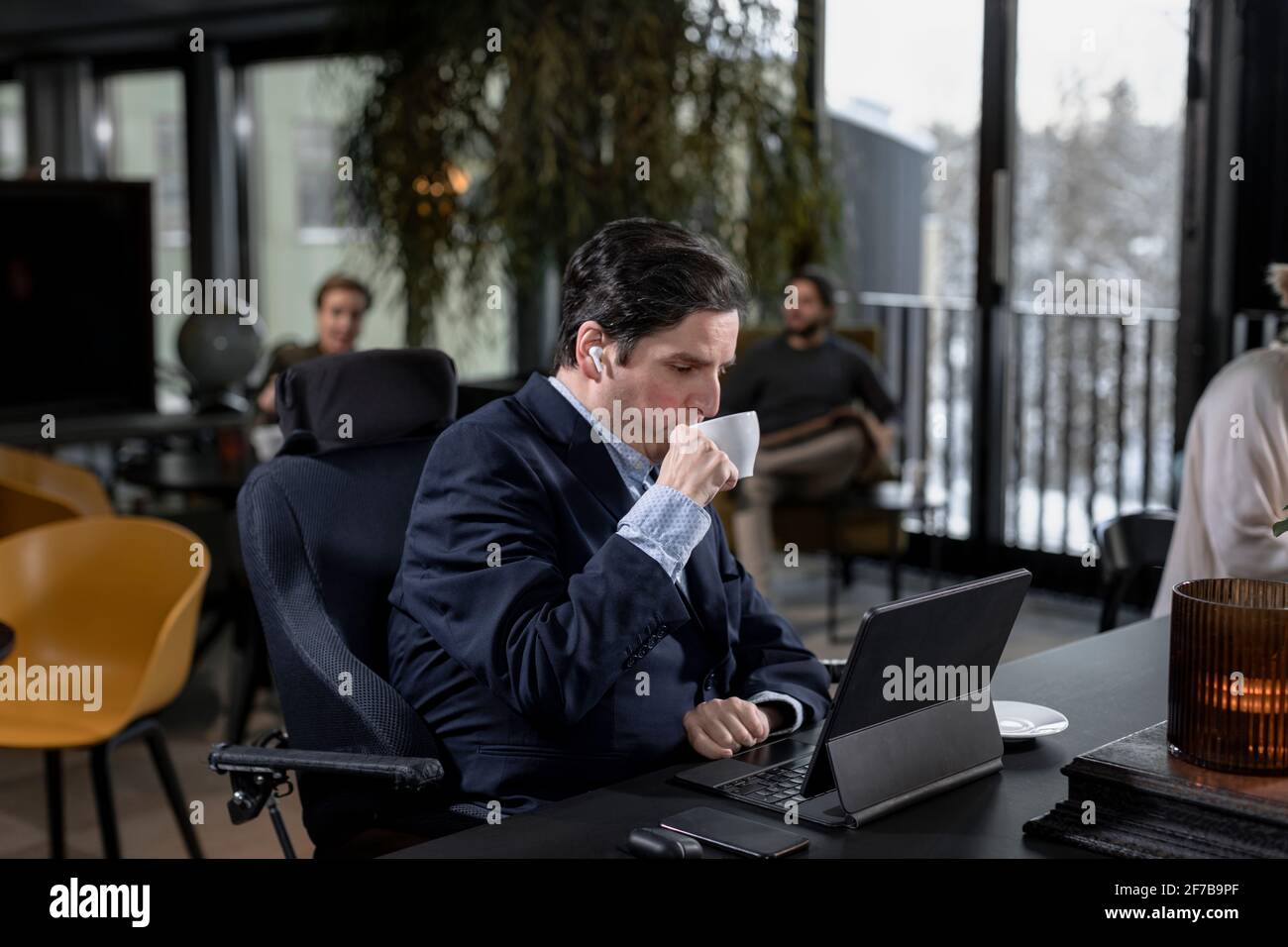 Geschäftsmann im Café mit Blick auf digitale Tablets Stockfoto