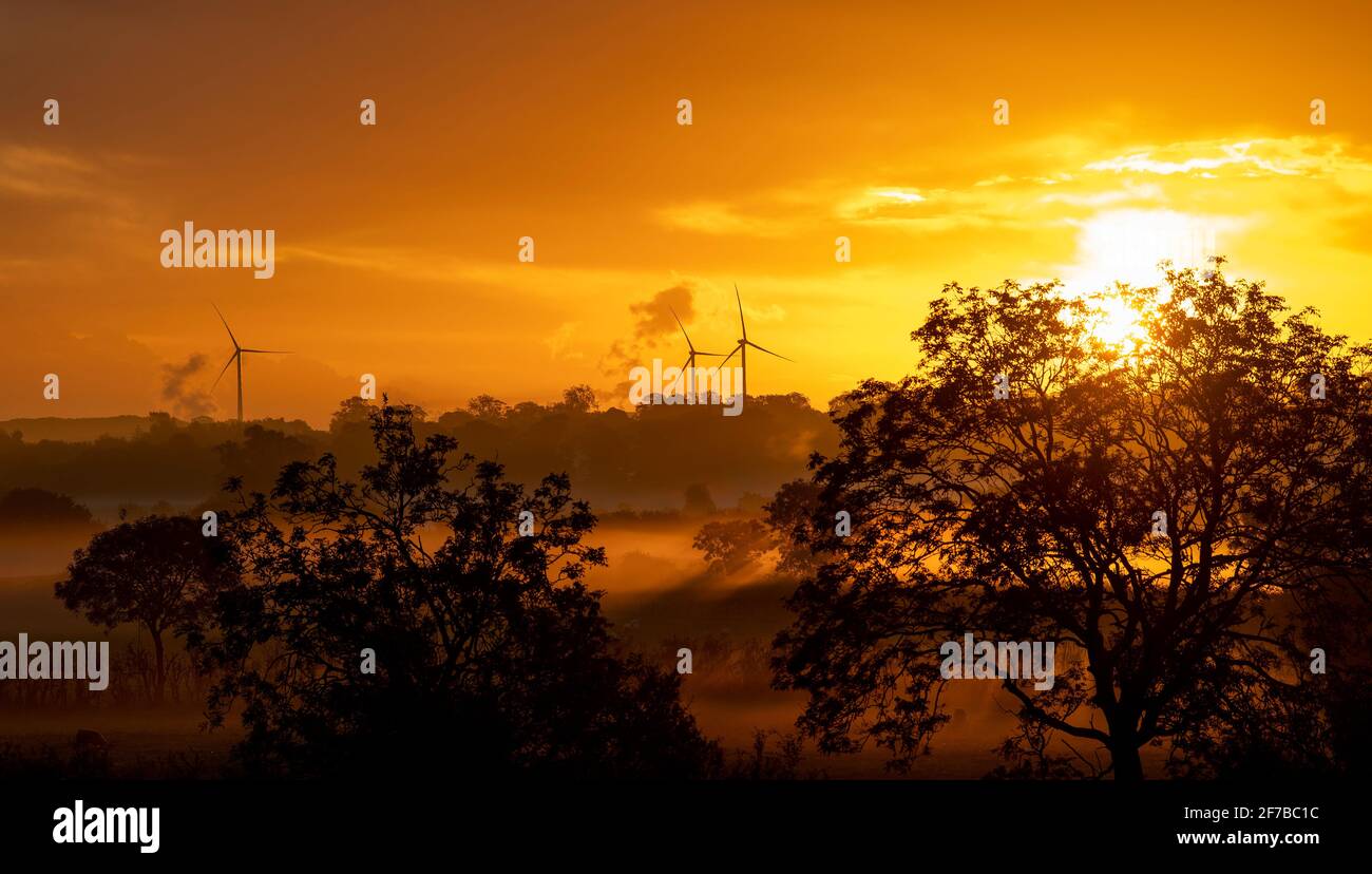 Sonnenaufgang auf dem Land am Rande von Darlington, mit Rauch aus der Industrie und Windkraftanlagen. Co. Durham, Großbritannien. Stockfoto