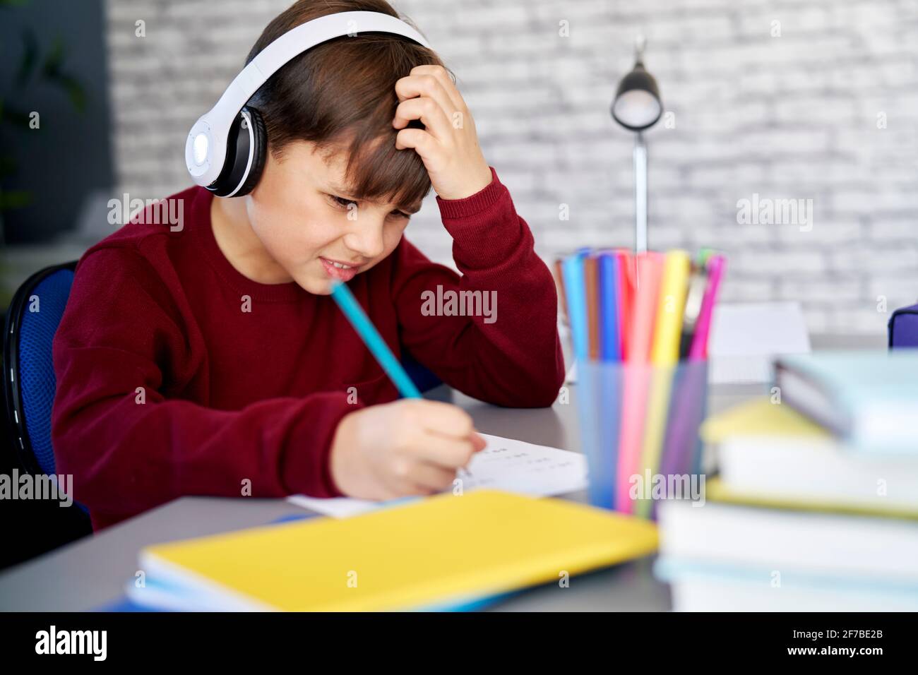 Frustrierter Schuljunge, der zu Hause Hausaufgaben macht Stockfoto